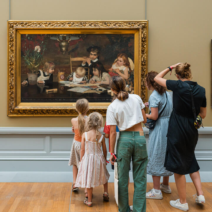 Familie met kinderen kijkt naar een schilderij in het Museum voor Schone Kunsten van Gent