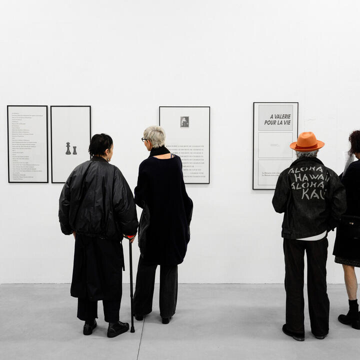 Bezoekers bij drukwerk in de tentoonstelling 'Avis au lecteur: de boekwerken van Jan Vercruysse' in Herbert Foundation - Loods