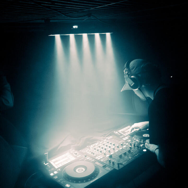 DJ achter de draaitafels in ondergrondse club