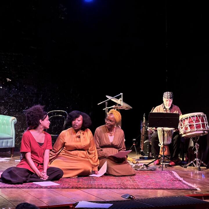 drie actrices en een muzikant op een podium