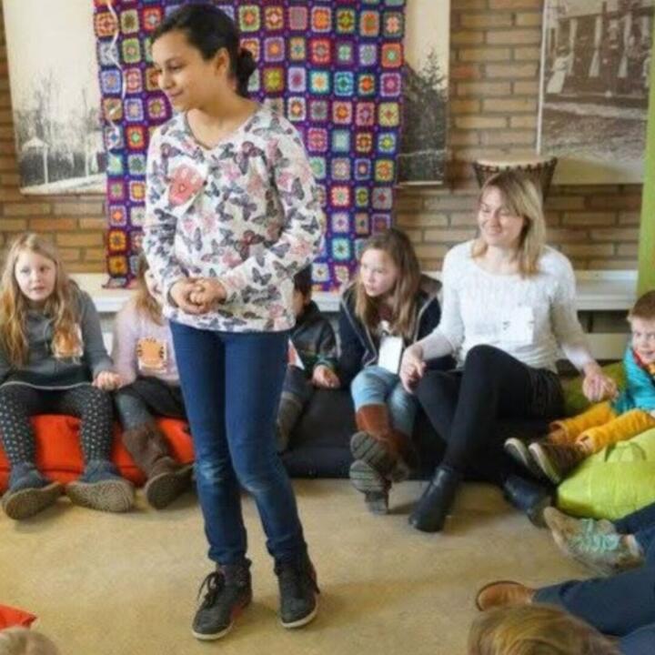 Lien Peynsaert in een kring met kindjes