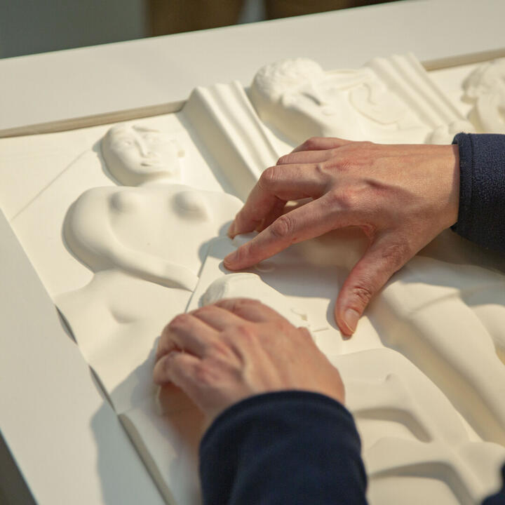 Bezoeker voelt aan voelplaat in het Museum voor Schone Kunsten