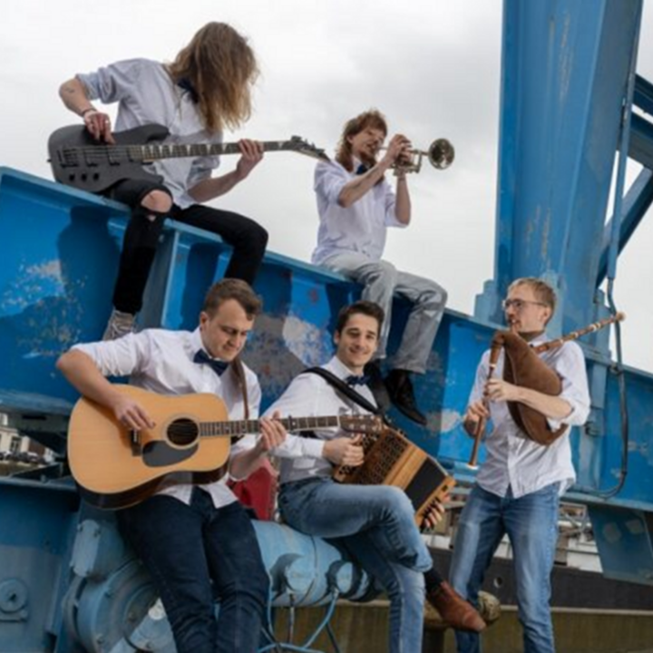 Kwintet Gestrikt bespelen hun instrumenten aan de voet van een grote containerkraan.