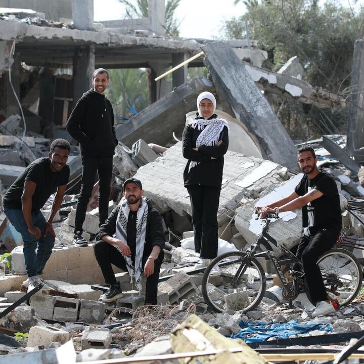 5 mensen tussen het puin van verwoeste gebouwen in Gaza Palestina