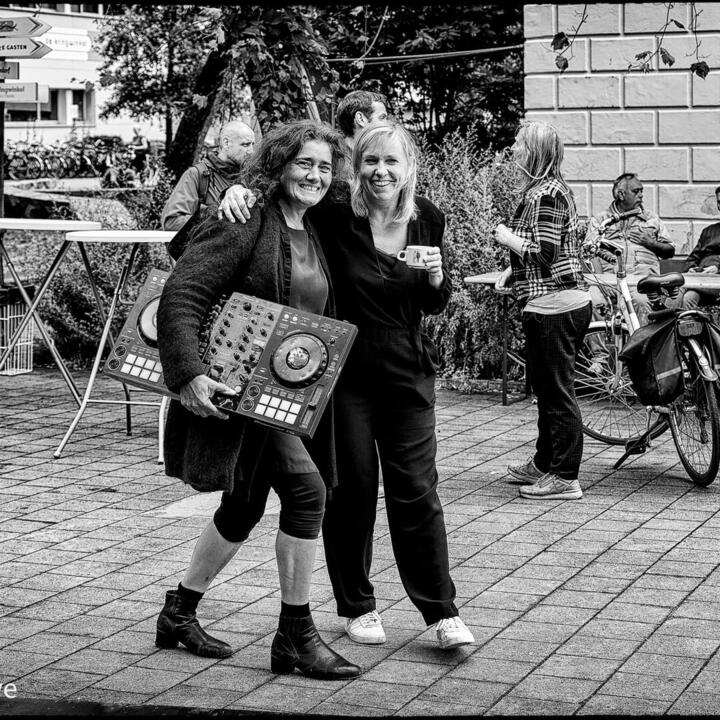 DJ tanasha met haar draaitafel onder de arm samen met een vriendin op straat