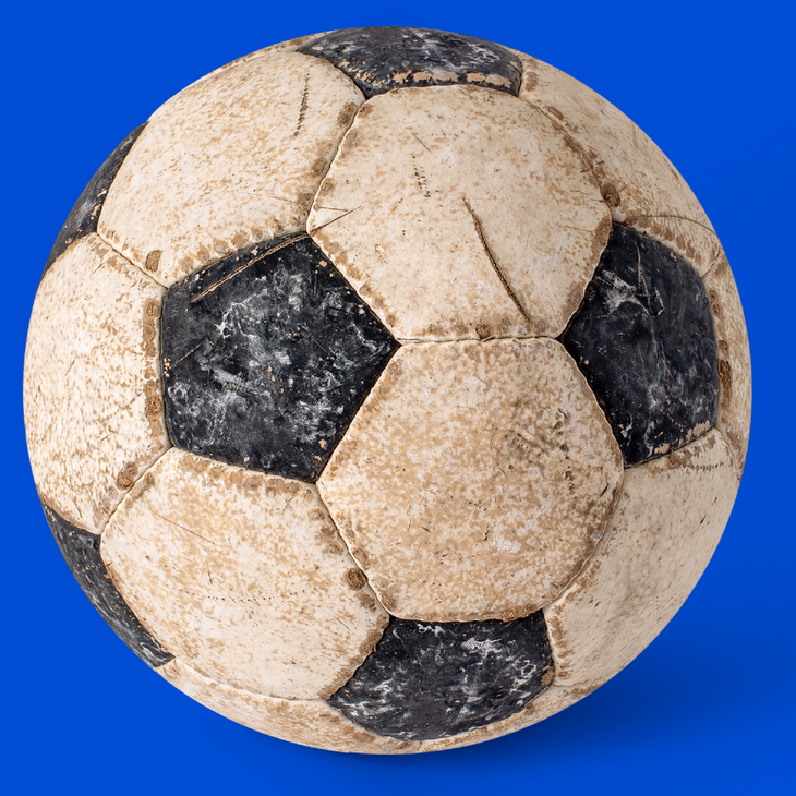 Het campagnebeeld van de expo 'Buitenspel - Voetbal in de stad' in het STAM: een oude voetbal met een blauwe achtergrond.